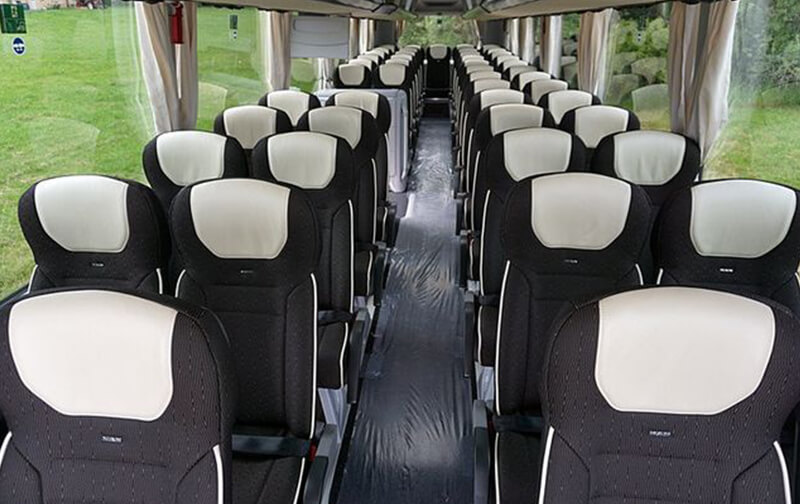 Interno di un pullman di grande capienza con sedili reclinabili e corridoio centrale